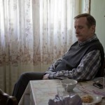 Slavko seated alone at a kitchen table